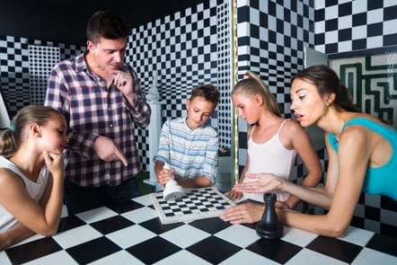 People enjoying a fun board game in a modern, checkered room with vibrant decor.